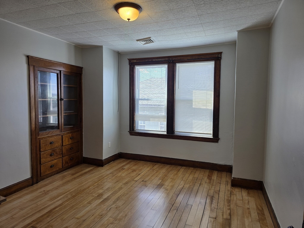 2 Hillside Street, Unit 3 Worcester, MA 01610 - Photo 11 of 23 a view of an empty room with wooden floor and a window