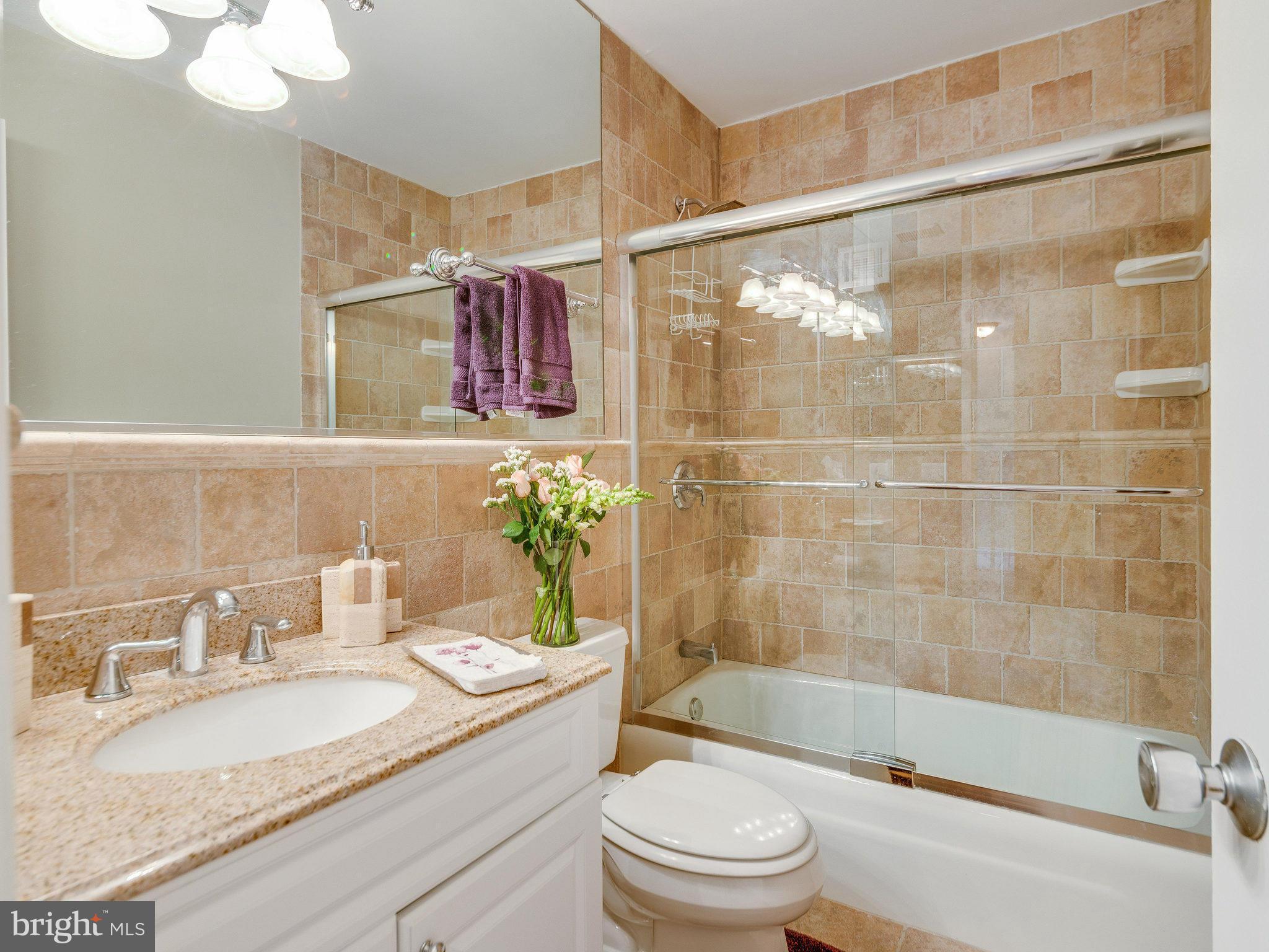 2269 Wheelwright Court Reston, VA 20191 - Photo 18 of 28 a bathroom with a granite countertop sink a toilet a mirror a bathtub and shower