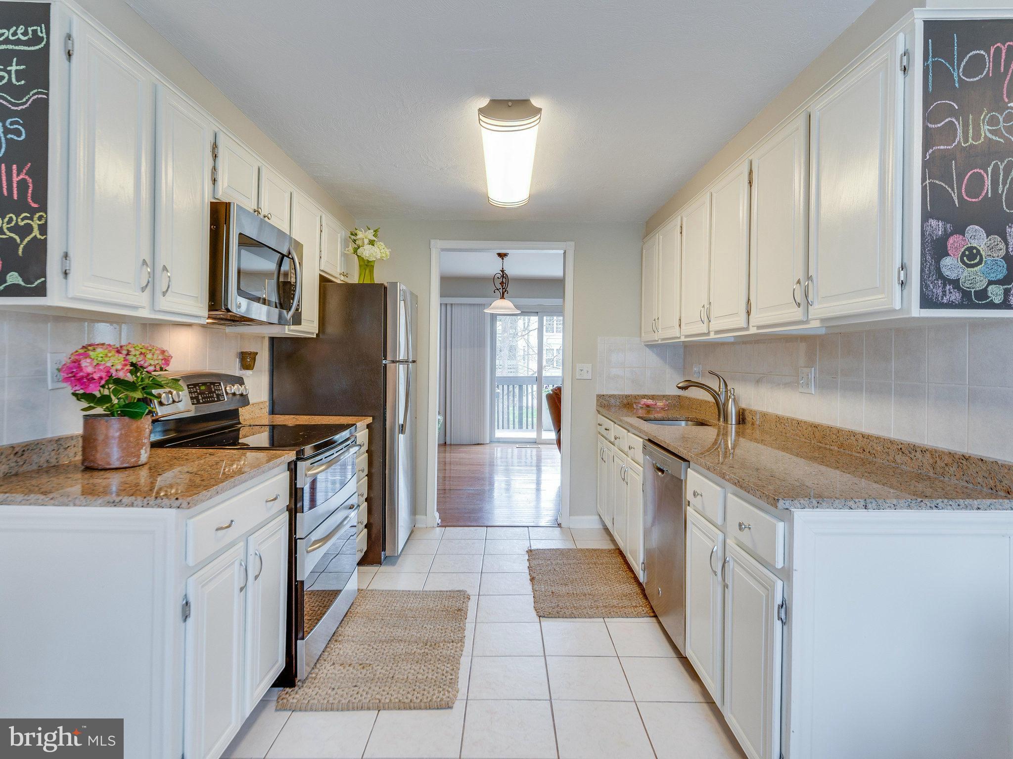 2269 Wheelwright Court Reston, VA 20191 - Photo 4 of 28 a kitchen with stainless steel appliances granite countertop a sink and cabinets