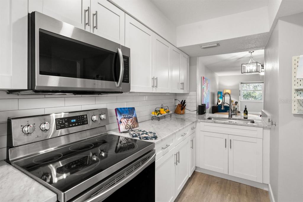 300 Clyde Lane, Unit 215 Dunedin, FL 34698 - Photo 13 of 60 a kitchen with a stove and a microwave