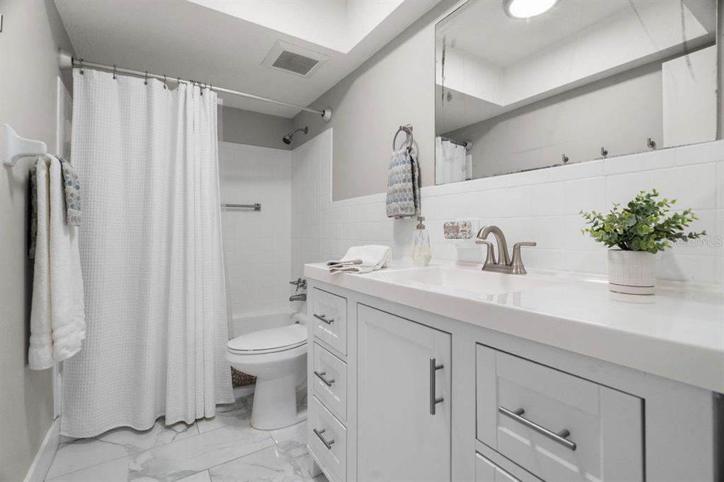 300 Clyde Lane, Unit 215 Dunedin, FL 34698 - Photo 18 of 60 a bathroom with a sink a toilet and shower curtain