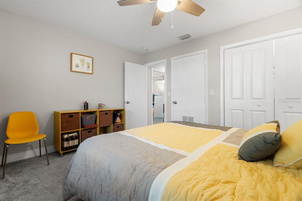 300 Clyde Lane, Unit 215 Dunedin, FL 34698 - Photo 20 of 60 a bedroom with a bed and a chandelier