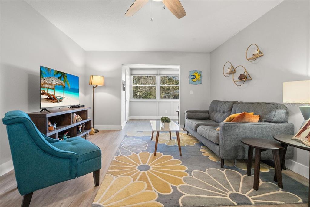 300 Clyde Lane, Unit 215 Dunedin, FL 34698 - Photo 9 of 60 a living room with furniture a window and a flat screen tv