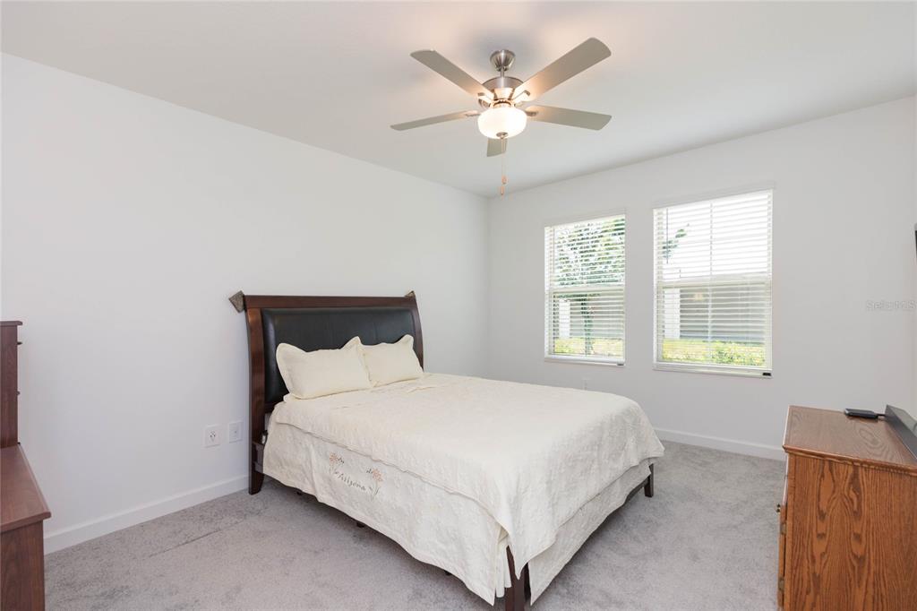 10806 Gable Dig Loop San Antonio, FL 33576 - Photo 23 of 73 a large bed sitting in a bedroom next to a window