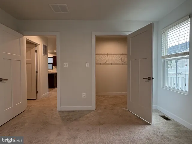 an empty room with windows and closet