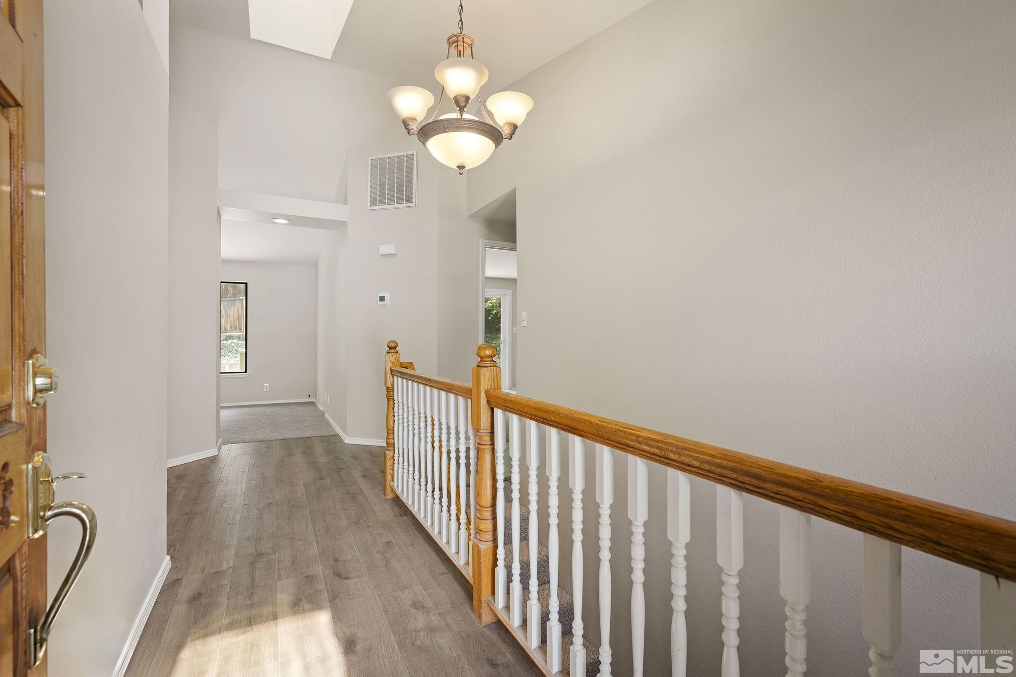 540 Citadel Road Reno, NV 89503 - Photo 3 of 30 a view of a hallway with wooden floor and chandelier