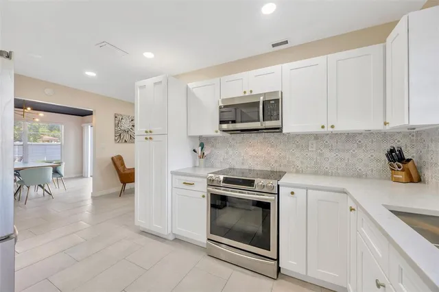 a kitchen with stainless steel appliances granite countertop a stove a sink and a microwave