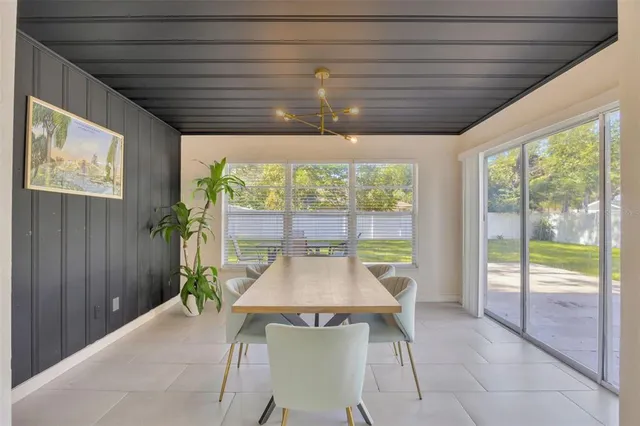 a dining room with furniture and a large window