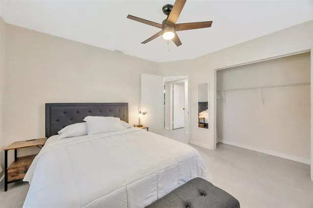 a bedroom with a large bed and a ceiling fan