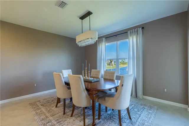 a dining room with furniture a chandelier and wooden floor