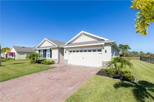a view of a house with a yard and potted plants