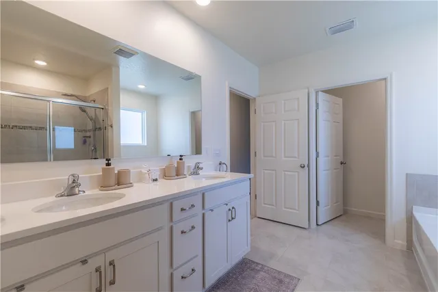 a bathroom with a double vanity sink and mirror