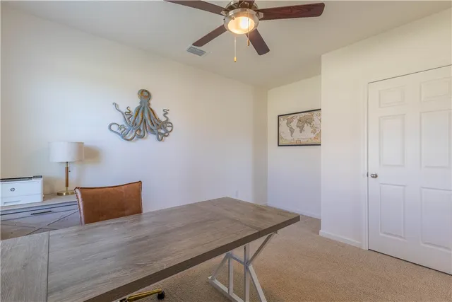 a view of a room with wooden floor and ceiling fan