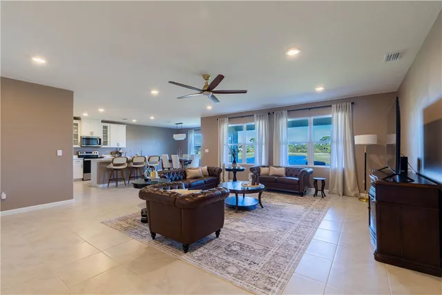 a living room with furniture kitchen view and a large window
