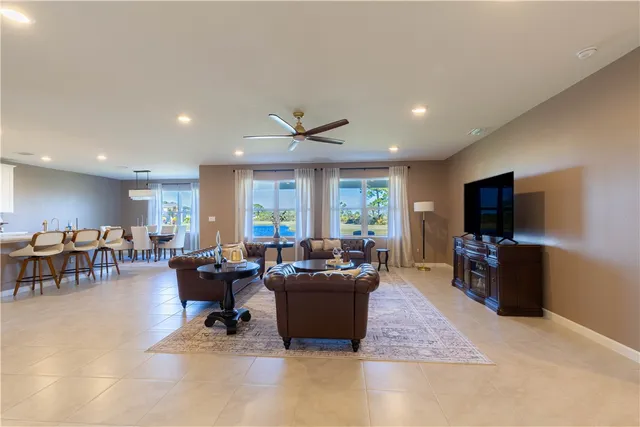 a living room with furniture a flat screen tv and a large window