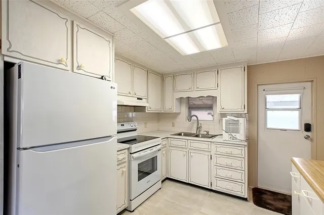 a kitchen with white cabinets and white appliances