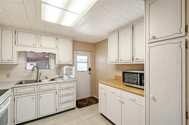 a kitchen with cabinets stainless steel appliances a sink and wooden floor