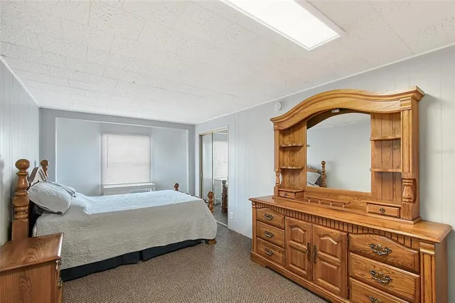 a bedroom with a bed and dresser with mirror