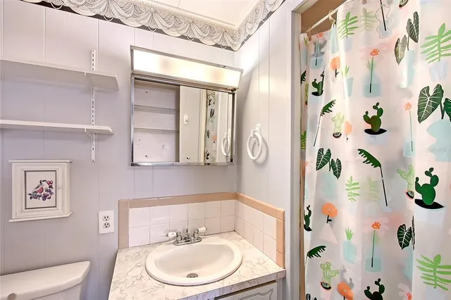 a bathroom with a sink and mirror with toilet