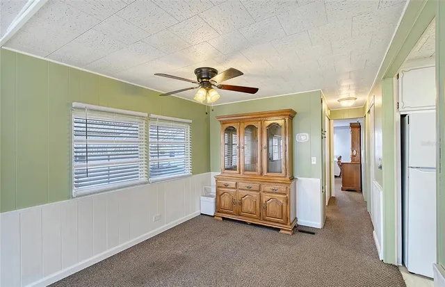 a view of an empty room with a ceiling fan and windows