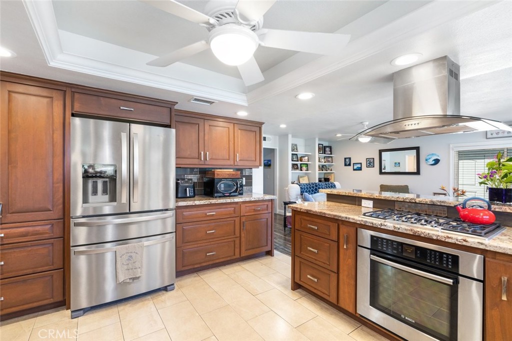 30198 La Primavera Street Temecula, CA 92592 - Photo 11 of 50 a kitchen with granite countertop stainless steel appliances and wooden cabinets