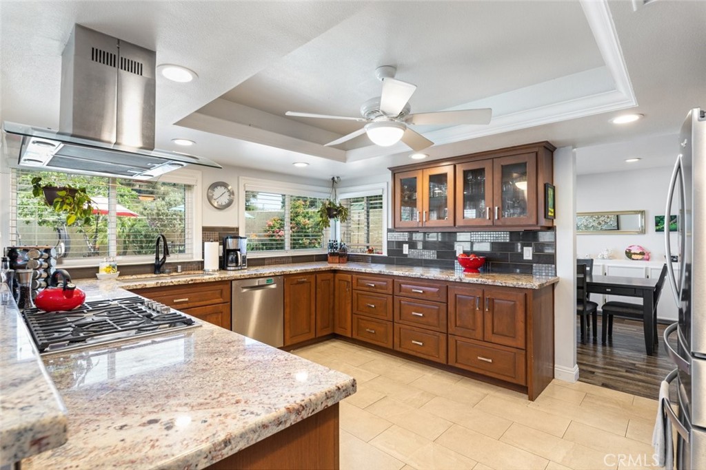 30198 La Primavera Street Temecula, CA 92592 - Photo 12 of 50 a kitchen with stainless steel appliances granite countertop a stove a sink dishwasher and cabinets with wooden floor