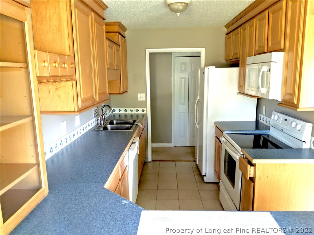 6653 Vaughn Road Fayetteville, NC 28304 - Photo 4 of 7 a kitchen with granite countertop a sink a counter top space and stainless steel appliances