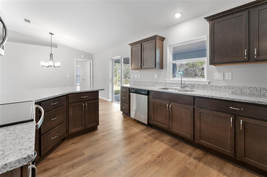 9461 North Sandree Drive Citrus Springs, FL 34434 - Photo 13 of 50 a kitchen with a sink and wooden cabinets