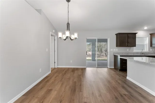 a view of a livingroom with a chandelier wooden floor a chandelier and windows