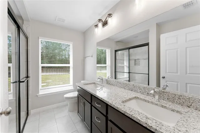 a bathroom with a granite countertop sink and a large mirror