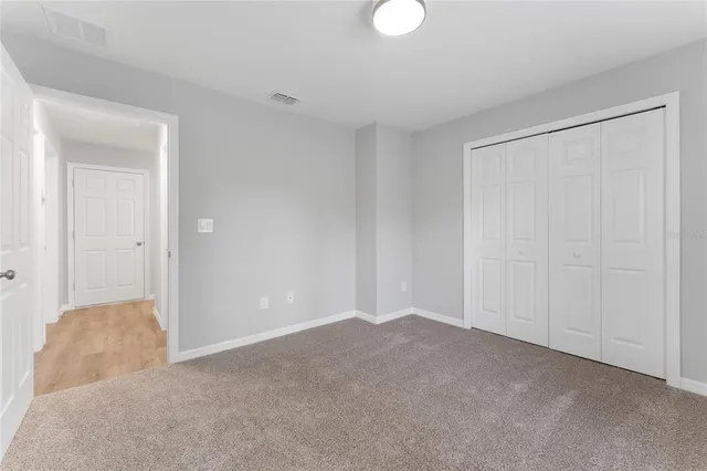 a view of an empty room and closet area