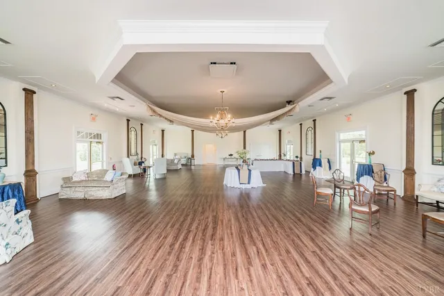a view of an empty room with wooden floor fridge and a window