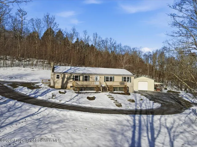 a view of a house with snow on the side of the road