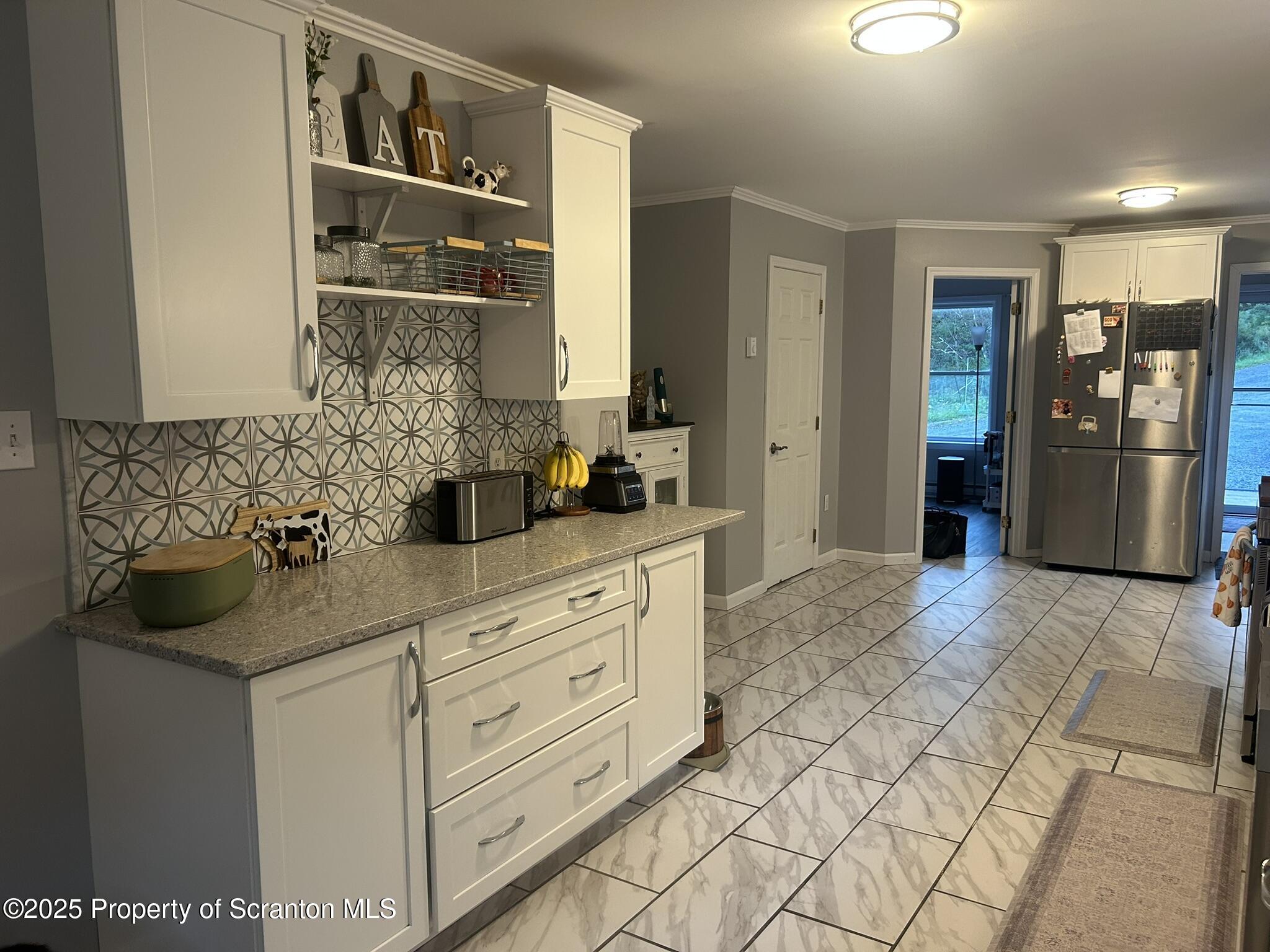 44 Franks Old Road Pleasant Mount, PA 18453 - Photo 13 of 37 a kitchen with stainless steel appliances kitchen island granite countertop a refrigerator and cabinets