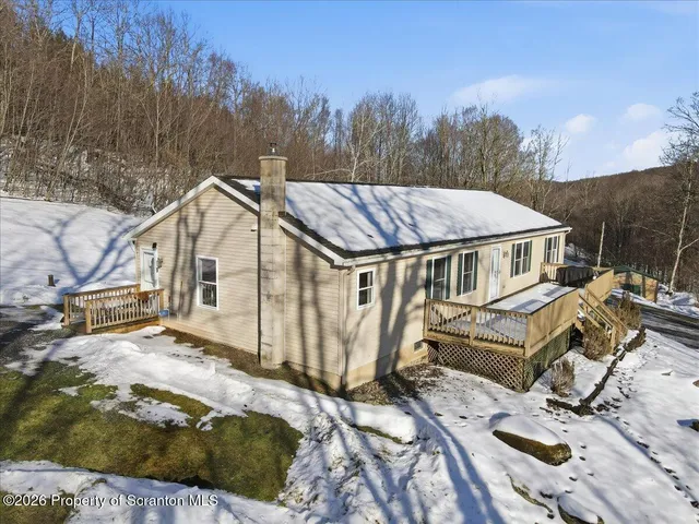 a view of a house with snow on the side of the road