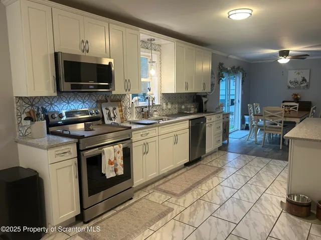 a kitchen with stainless steel appliances kitchen island granite countertop a refrigerator and cabinets