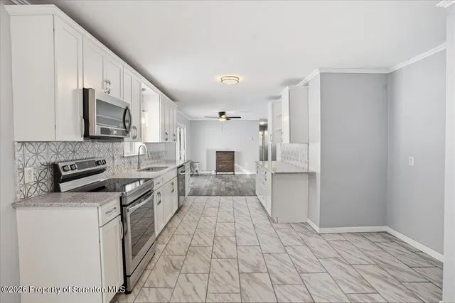 a kitchen with granite countertop a sink stove and cabinets