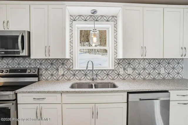 a view of empty room with wooden floor and window