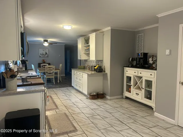 a living room with stainless steel appliances furniture a fireplace and a flat screen tv