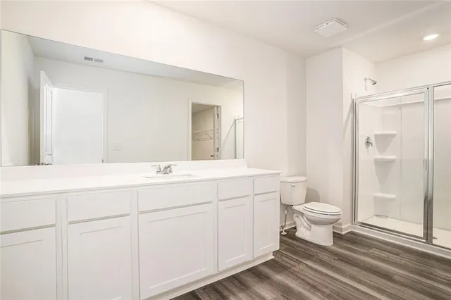 a bathroom with a sink a toilet a mirror and shower