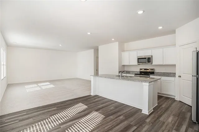 a kitchen with stainless steel appliances a refrigerator and a stove top oven