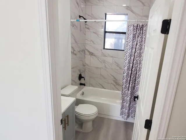 a bathroom with a toilet and a shower curtain