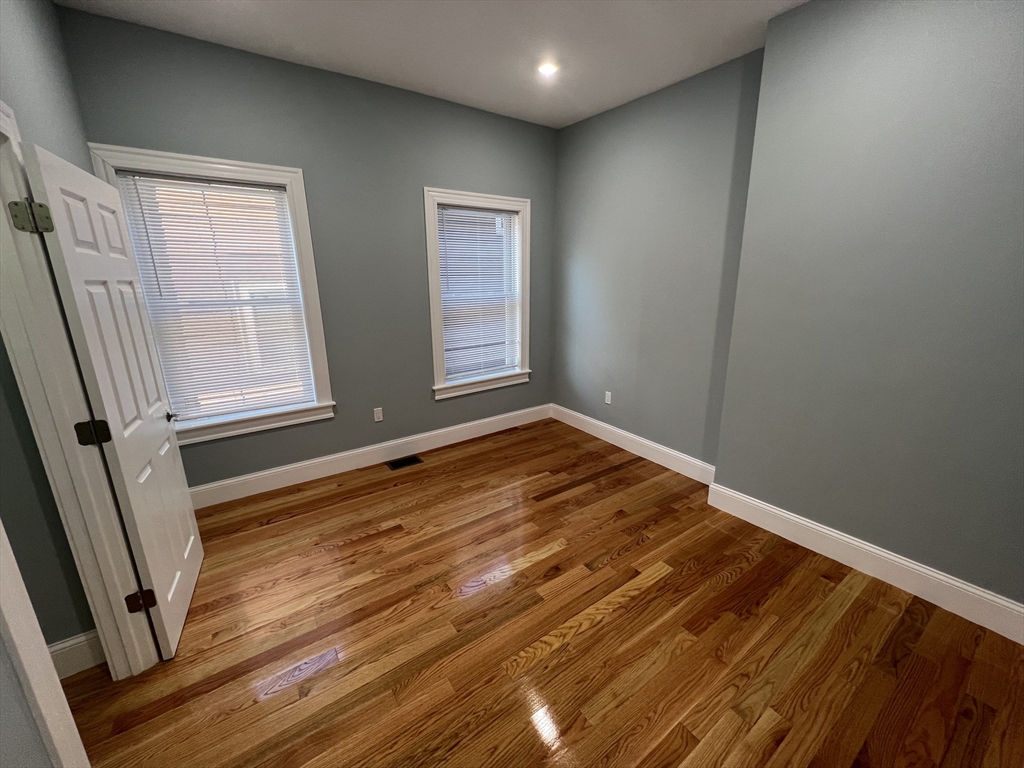 29 Alpine Street, Unit 1 Somerville, MA 02144 - Photo 18 of 33 an empty room with wooden floor and windows