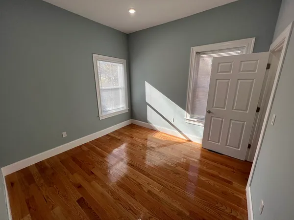 a view of empty room with wooden floor