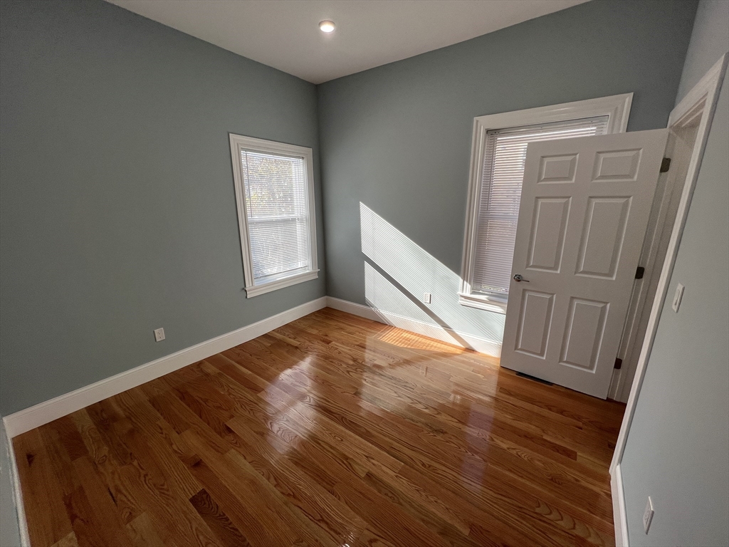 29 Alpine Street, Unit 1 Somerville, MA 02144 - Photo 26 of 33 an empty room with wooden floor and windows