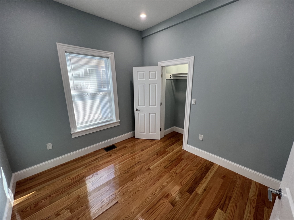 29 Alpine Street, Unit 1 Somerville, MA 02144 - Photo 29 of 33 a view of an empty room with wooden floor and a window