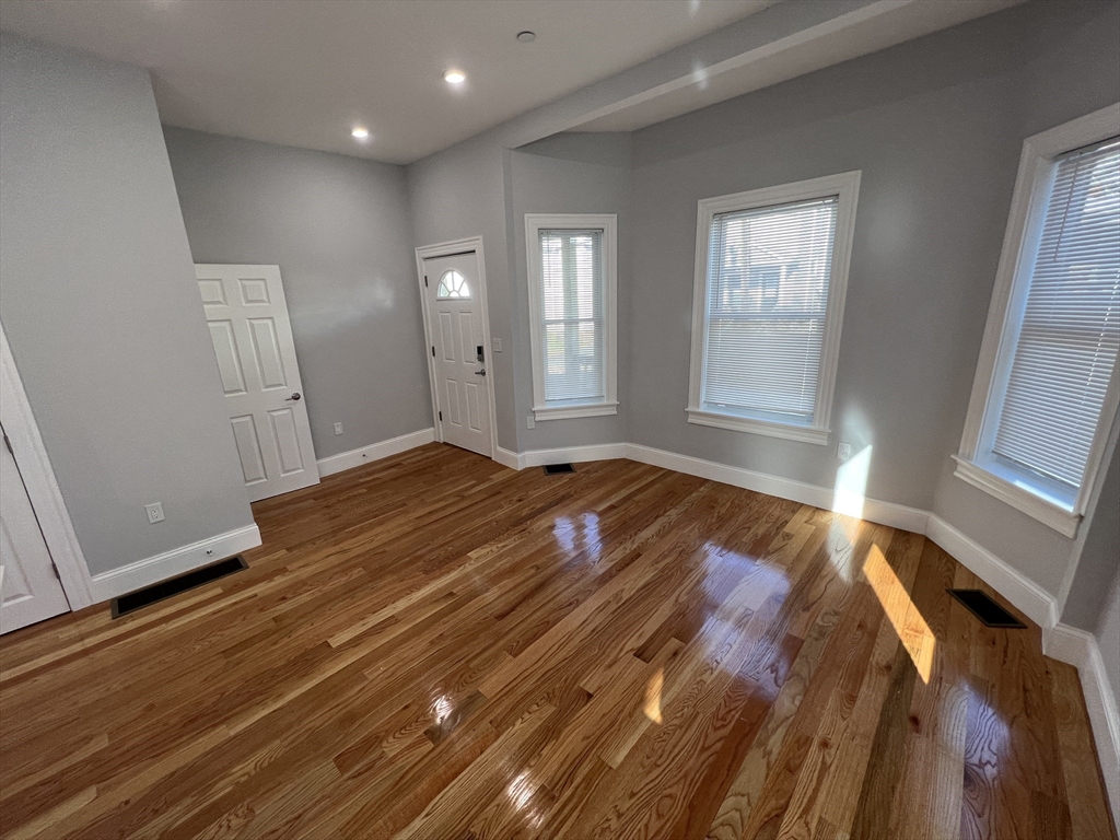 29 Alpine Street, Unit 1 Somerville, MA 02144 - Photo 10 of 33 an empty room with wooden floor and windows