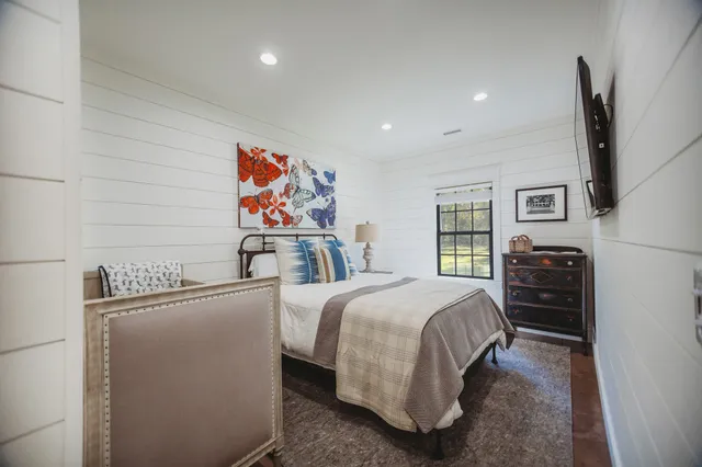 a bedroom with a bed mirror and window