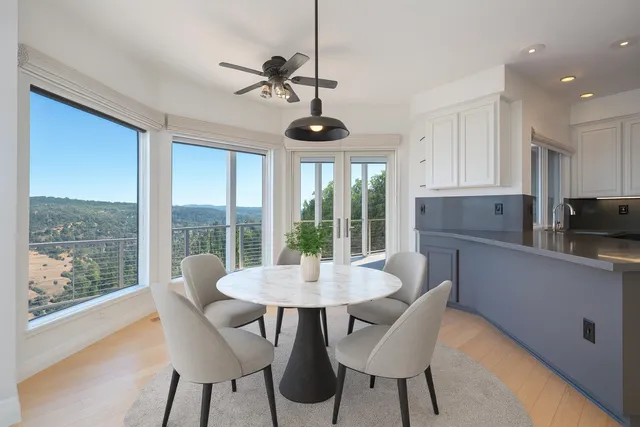 a view of a living room and floor to ceiling window with wooden floor