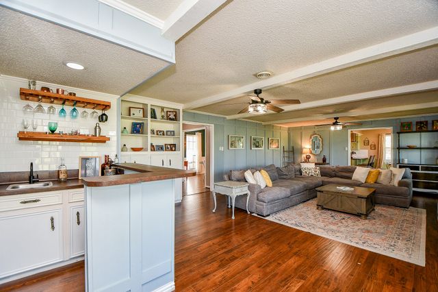 a living room with stainless steel appliances kitchen island granite countertop furniture and a large window